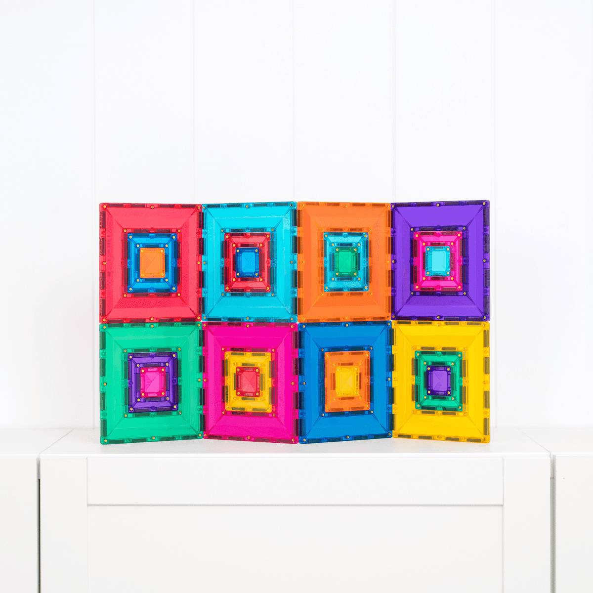 Colorful magnetic building tiles on a white surface