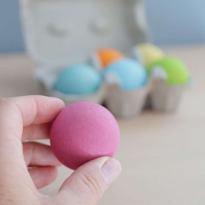 Grimm's Pastel Ball being held in fingers to show size and scale