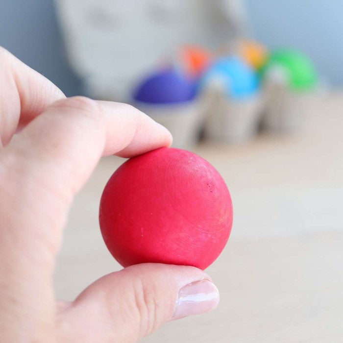 Grimm's Rainbow Ball being held in fingers to show size and scale