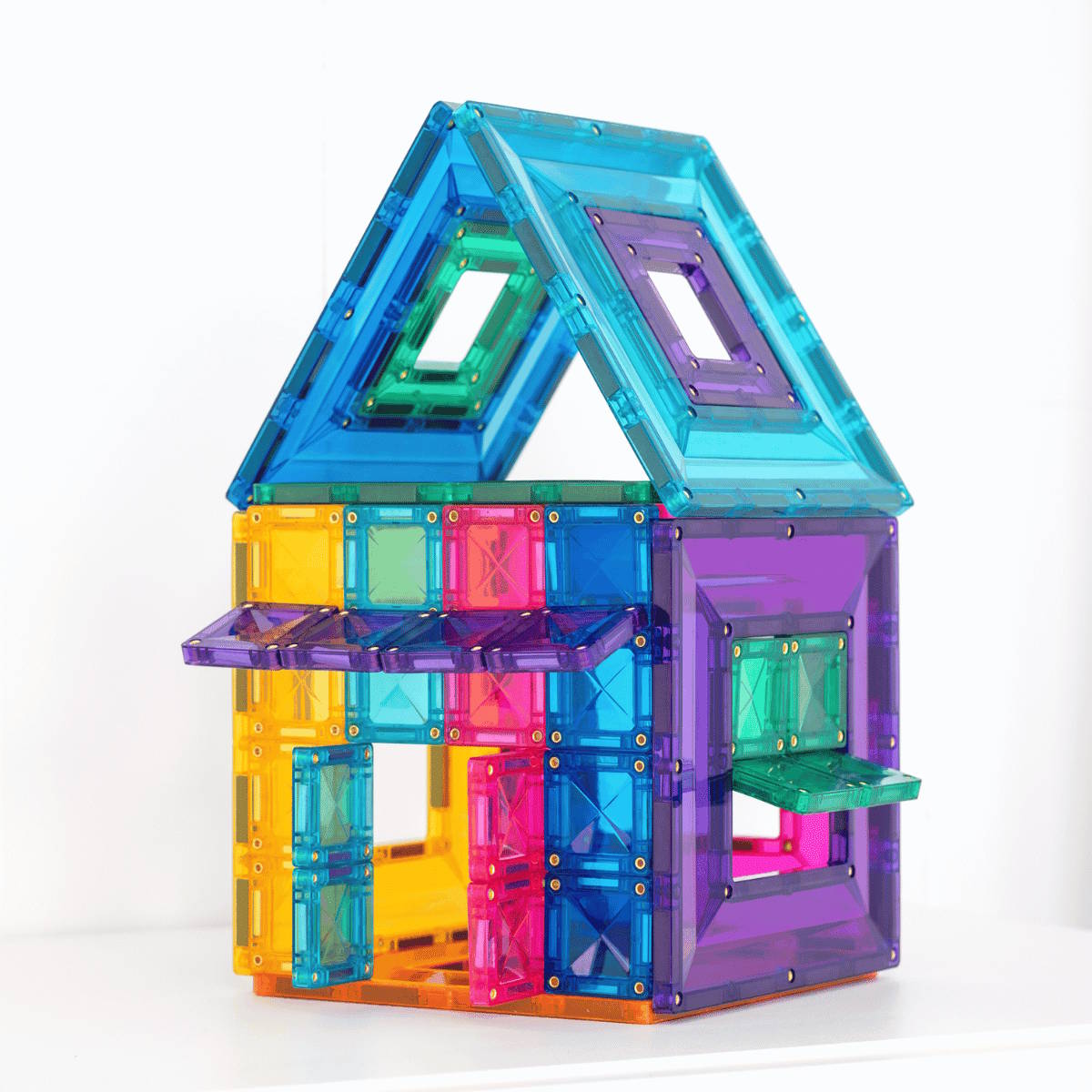 Colorful magnetic building tiles shaped like a house on a white background