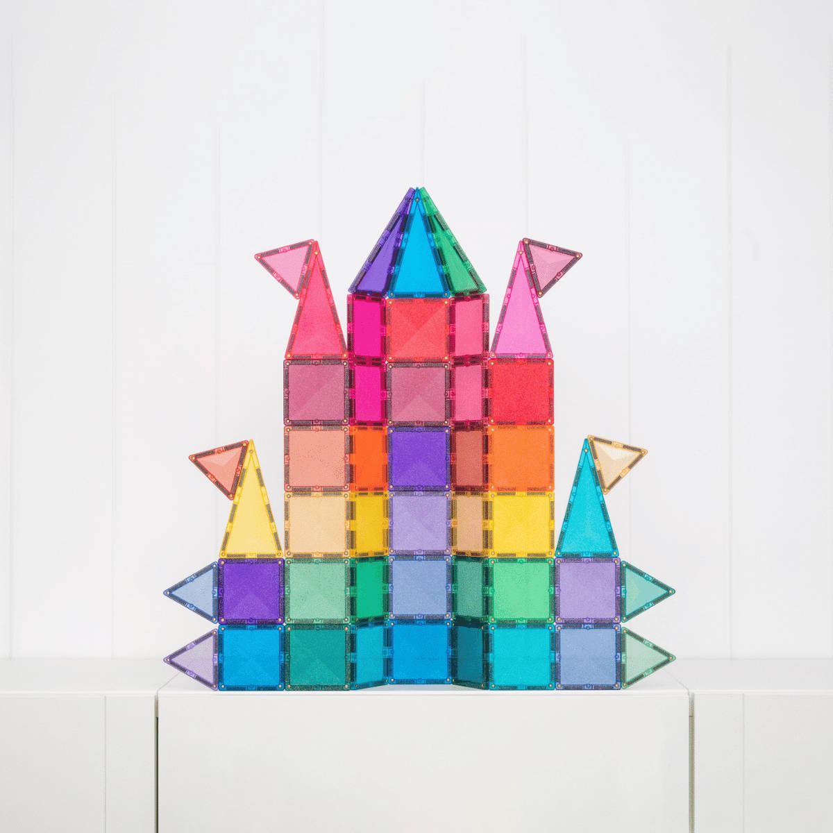 Colorful magnetic building tiles in a castle shape on a white background