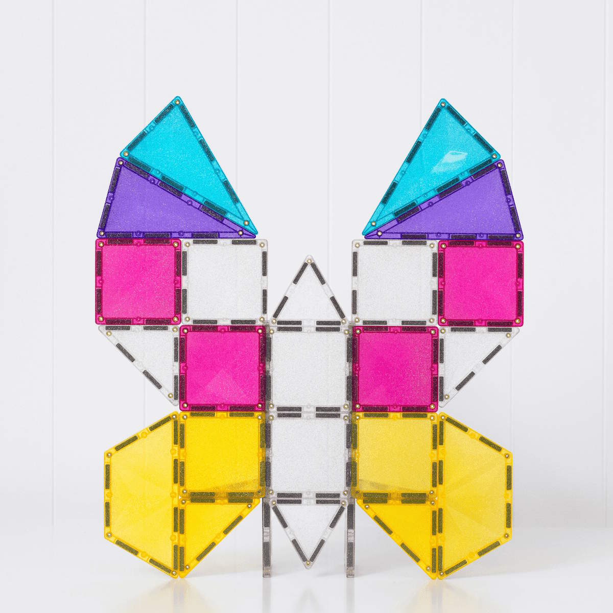 Colorful magnetic tiles used to create a 2D butterfly set on a white background