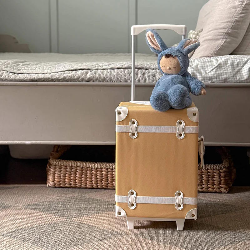 Olli Ella Cozy Dinkum Bunny Twiggy in blue sitting on a See-Ya Suitcase