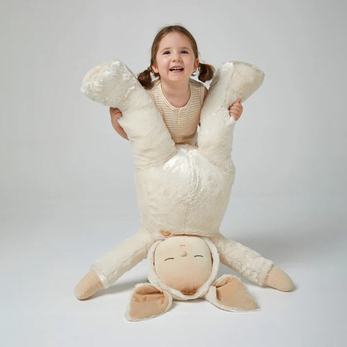 Child holding an extremely large white bunny rabbit plush toy