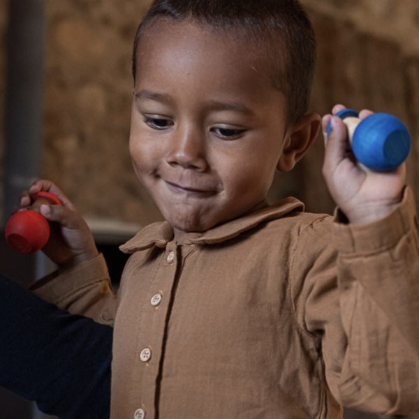 Little boy playing with Grapat Together wooden peg people nins