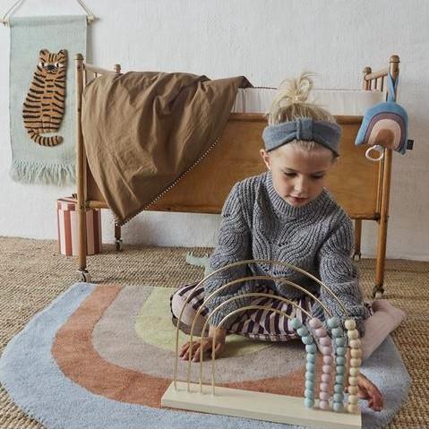 OYOY | Wooden Toy | Rainbow Abacus | girl playing on rainbow rug